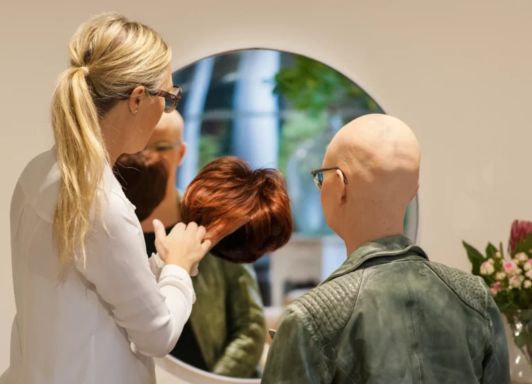 Franziska zeigt einer Frau mit Glatze die Vorteile Ihrer Methode anhand einer Perücke
